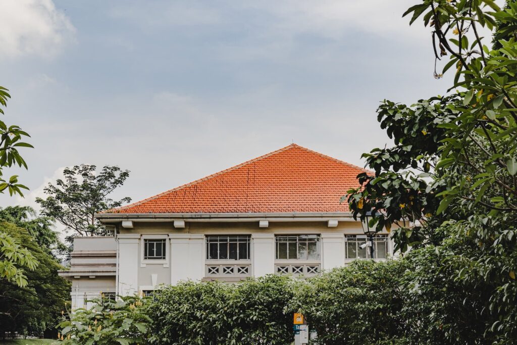 a white house with a red roof surrounded by trees